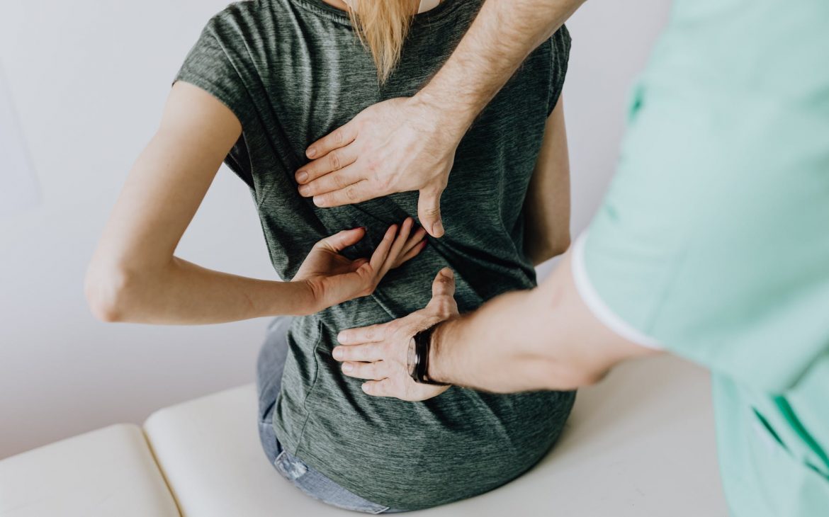 crop unrecognizable woman showing chiropractor painful spot on back BAD BACK